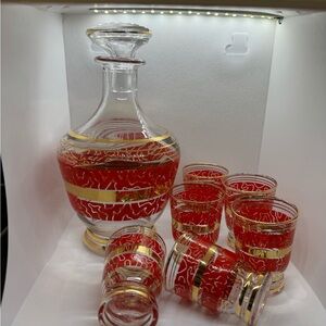 Chic MCM red and gold decanter with 6 shot glasses.